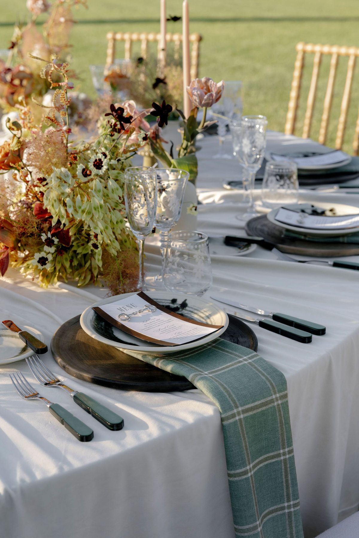 A place setting with plaid linen and autumn florals