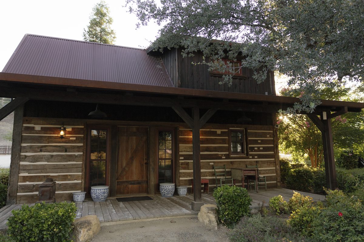 A timber guest cabin beneath the oaks