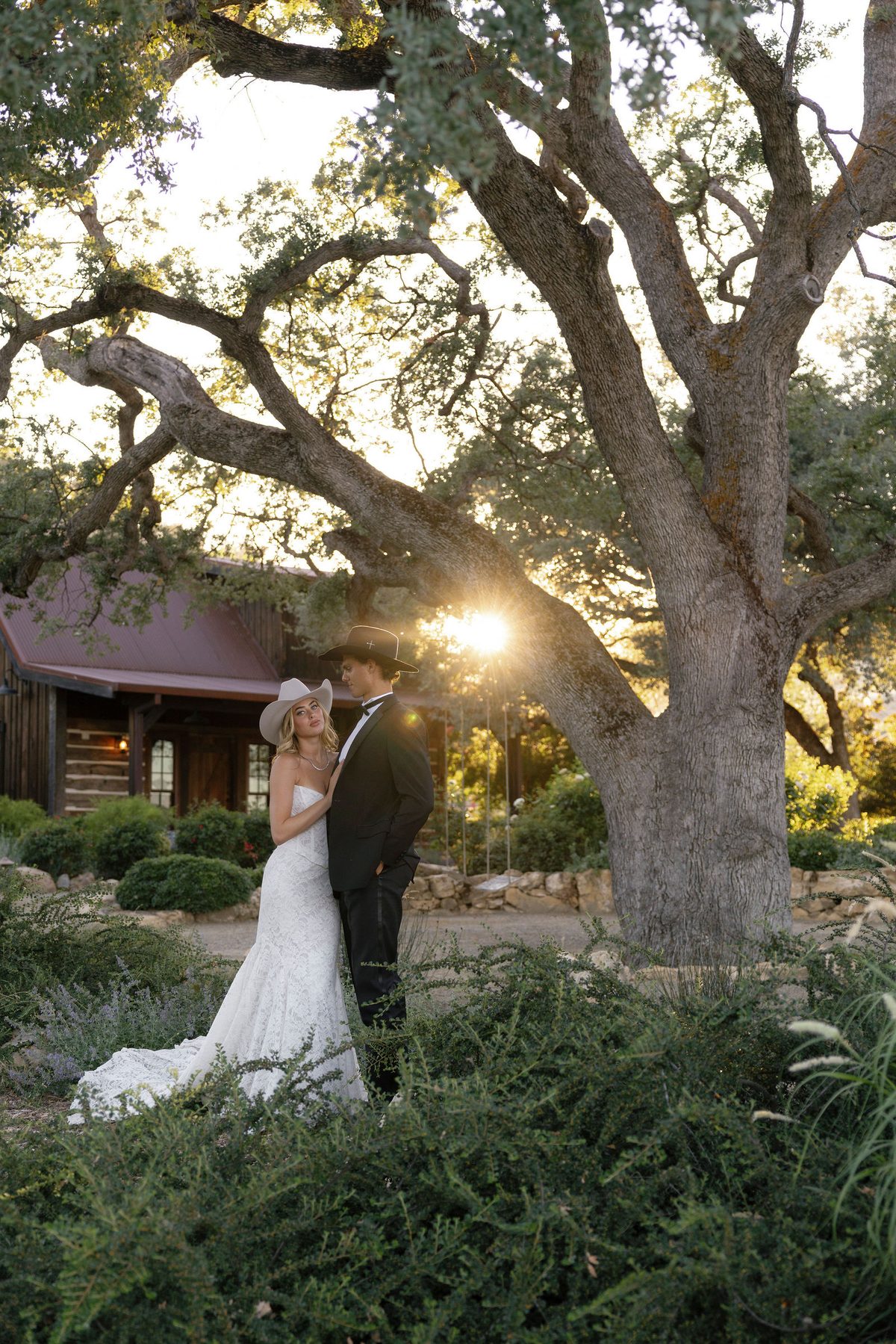 The couple beneath a great oak as the sun drops