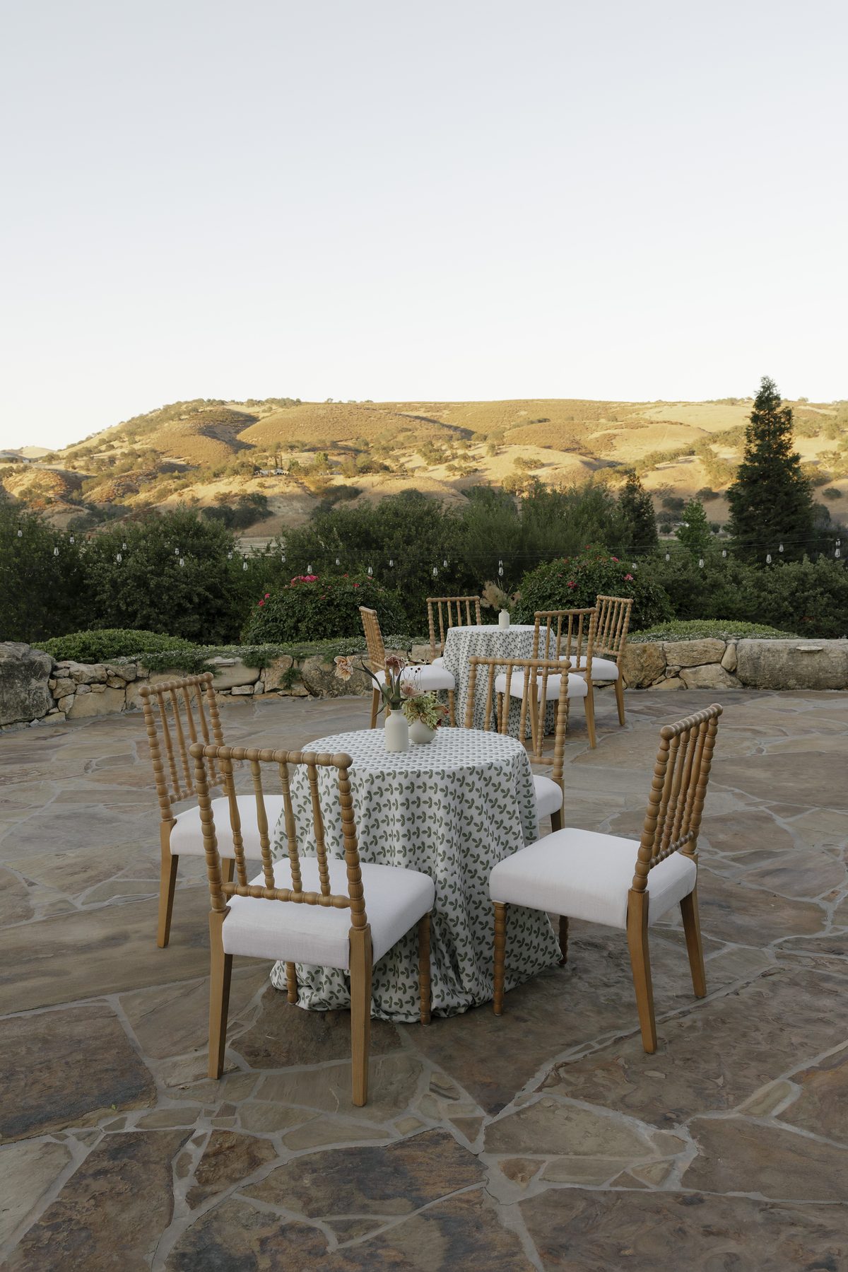 Tables set on the pool terrace beneath the hills