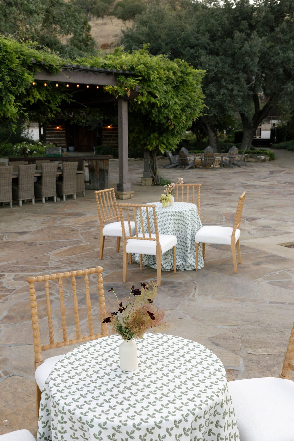A table on the pool terrace beneath the pergola