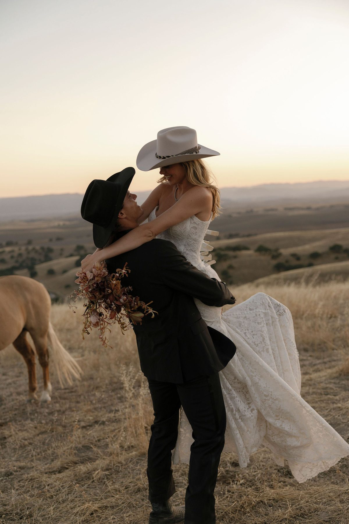 The couple embracing on the ridge at last light