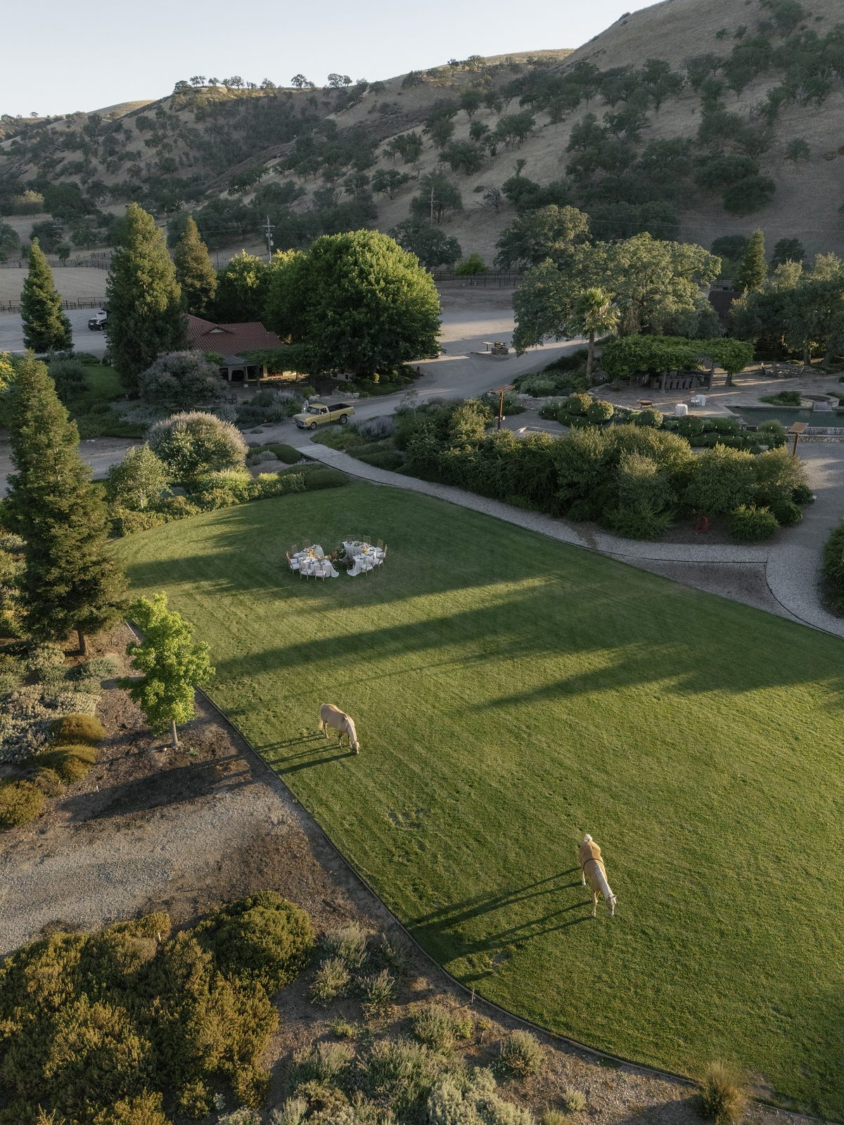 The lawn from the air with dinner set beneath the hills