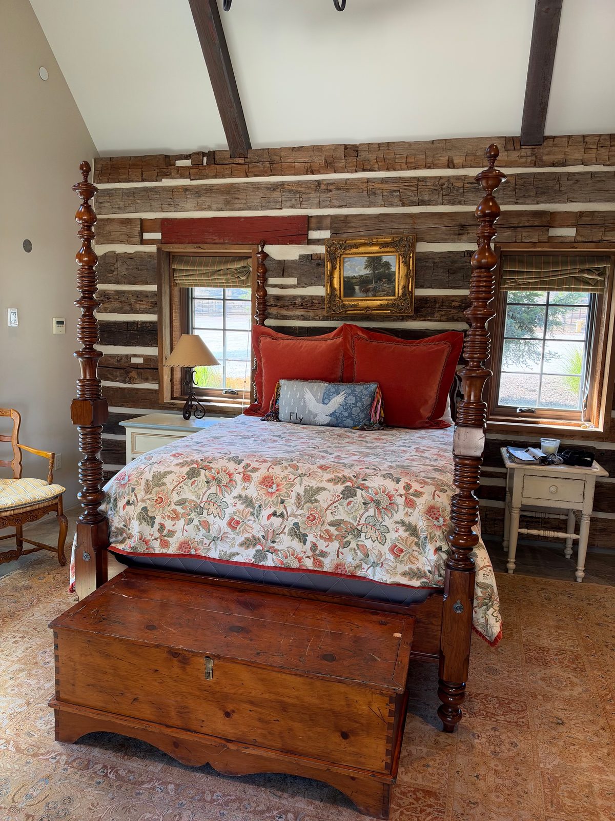 A guest bedroom with a carved four-poster bed