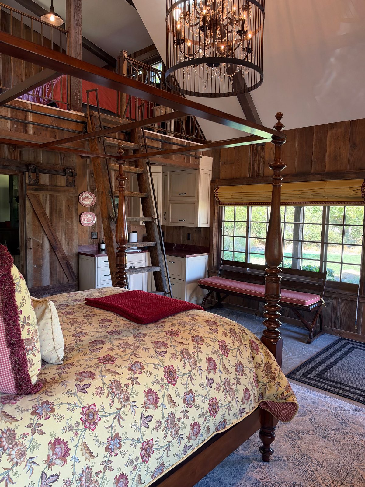 A four-poster guest bedroom with a floral quilt