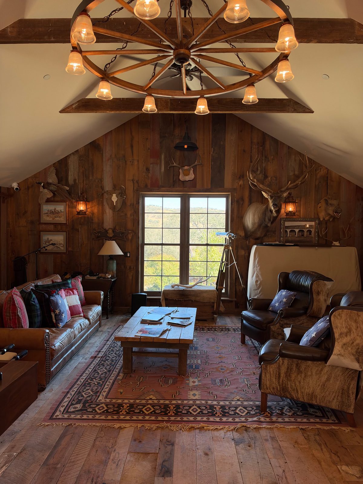 The saloon lounge with leather sofas beneath a wagon-wheel chandelier